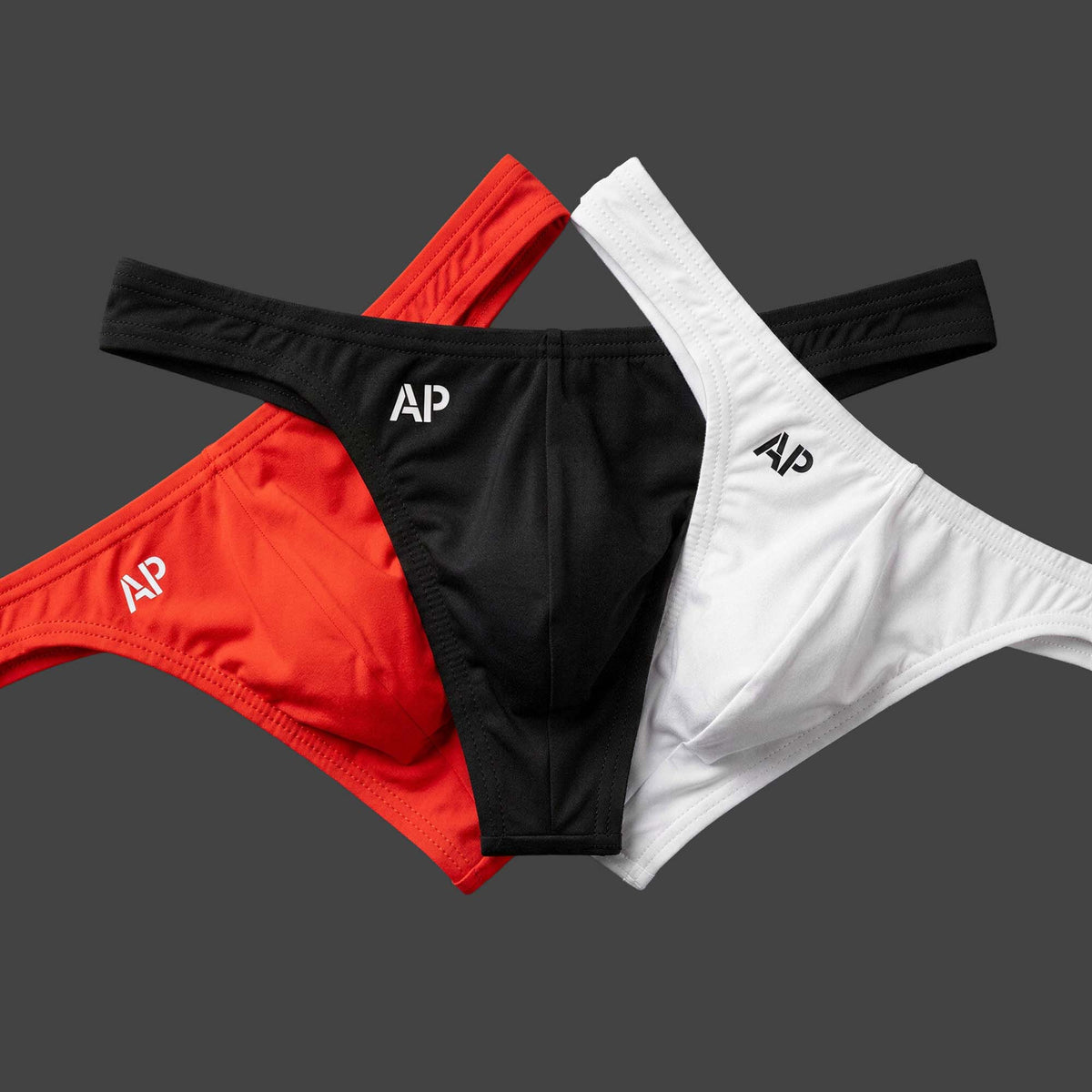 Pack: Pack x3 Tanga STATEMENT ROJO colores rojo, negro y blanco. Vista conjunto con las tres piezas en disposición abanico. Alepadron.